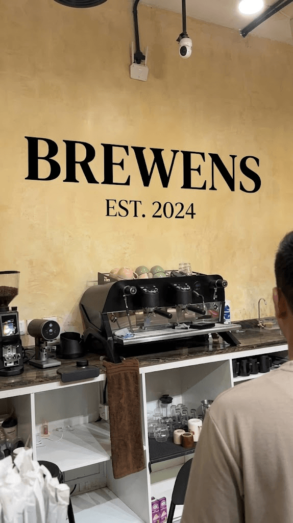 The espresso station with a professional dual-group machine and the BREWENS EST. 2024 wall